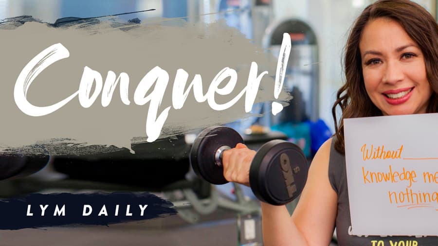 A woman smiling and holding a dumbbell in one hand while holding a book in the other, with the word Conquer! in bold text. The background shows gym equipment. Text reads LYM Daily and a quote Without knowledge means nothing.