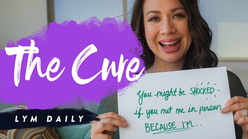 A person smiling and holding a sign that reads, You might be shocked if you met me in person because Im... Next to them is a purple brush stroke with the text The Cwre and Lym Daily at the bottom.