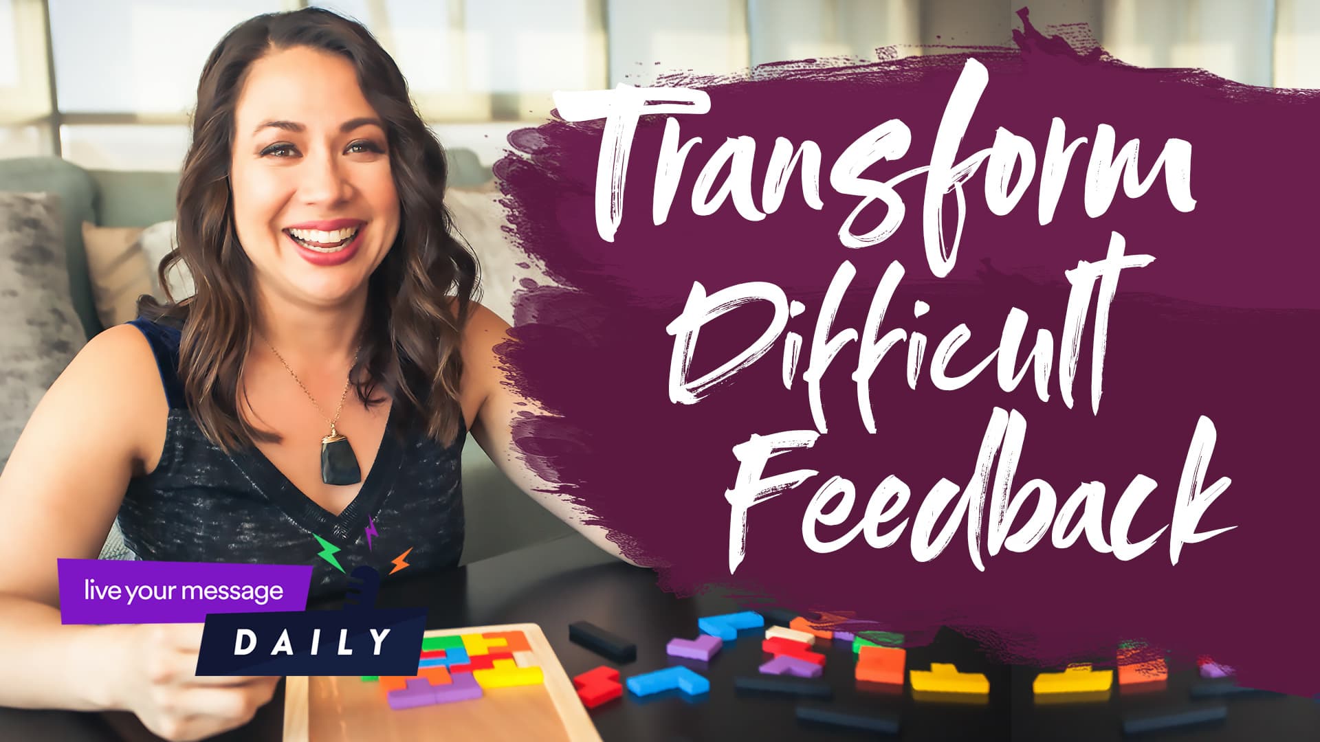 A woman smiles while sitting at a table with colorful puzzle pieces. The text on the image reads, Transform Difficult Feedback.