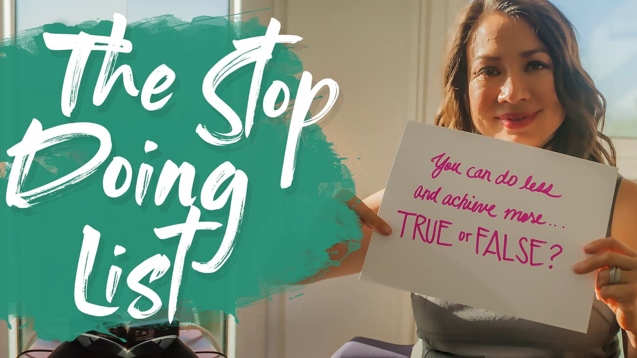 A person sitting indoors holds a sign reading, You can do less and achieve more... TRUE or FALSE? The image is overlaid with the text The Stop Doing List in large, stylized letters.