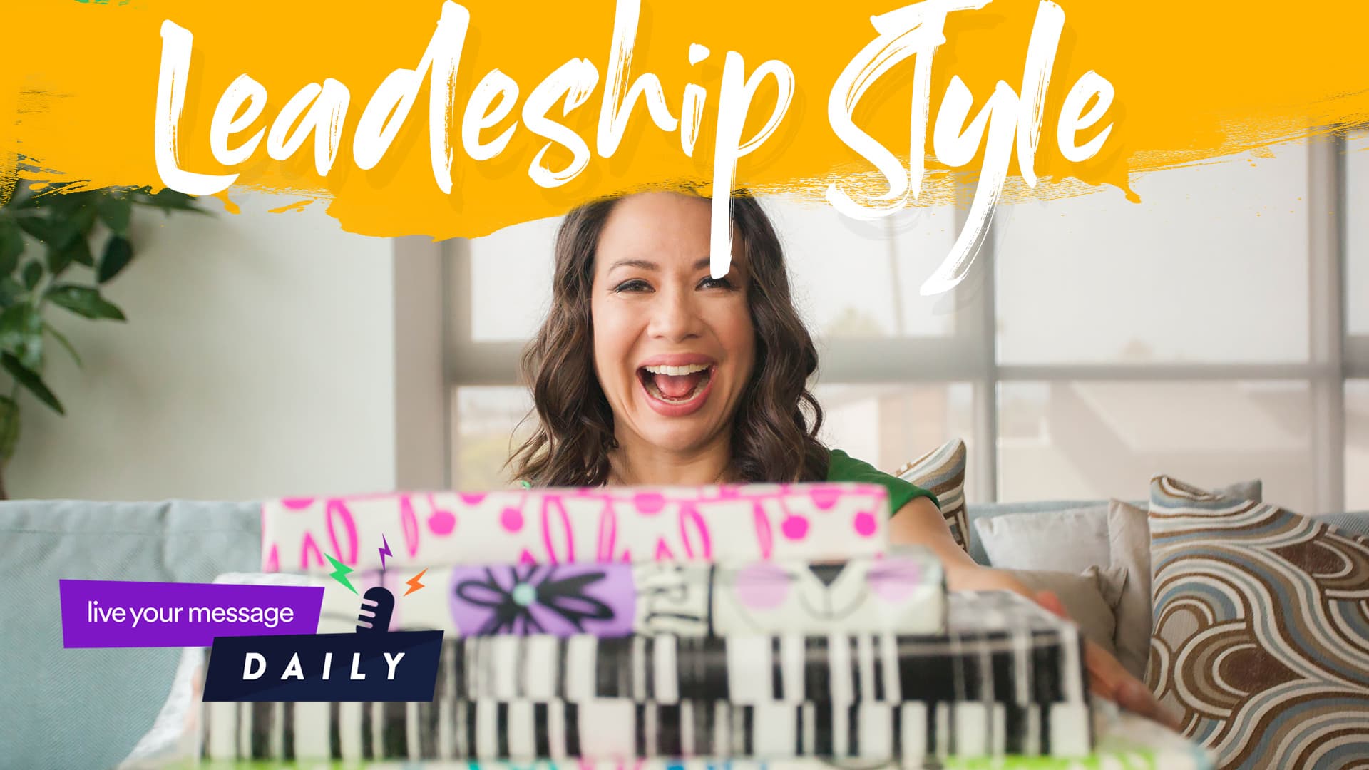 A smiling woman sitting on a couch is surrounded by colorful, wrapped gifts. The text Leadership Style appears above her, with a small logo reading live your message DAILY in the bottom left corner. The setting is bright and inviting.