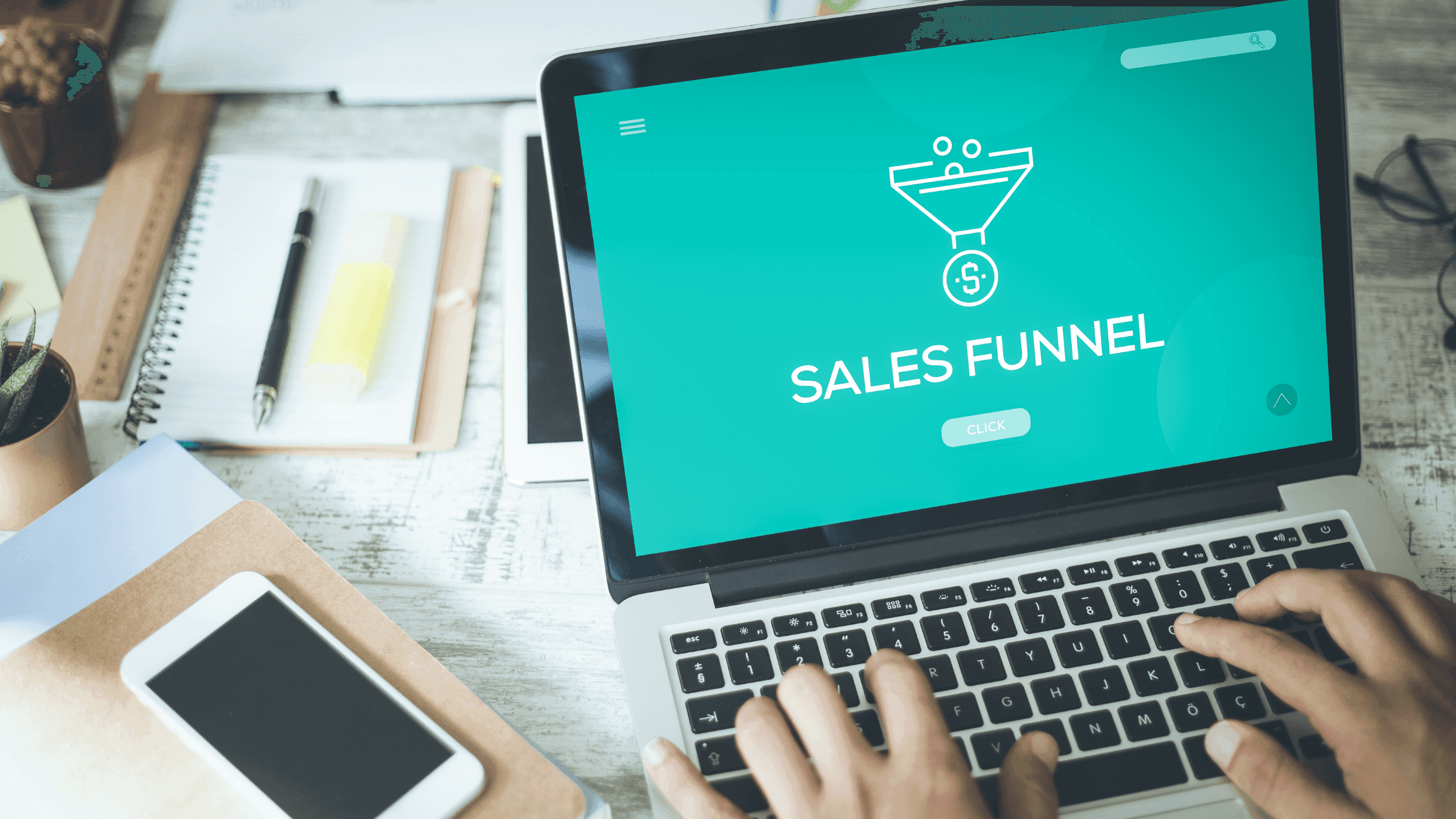 A person types on a laptop displaying a sales funnel graphic. The screen shows a funnel icon with a dollar sign, and the words Sales Funnel on a turquoise background. Nearby, there are a smartphone, notebook, and office supplies on the desk.