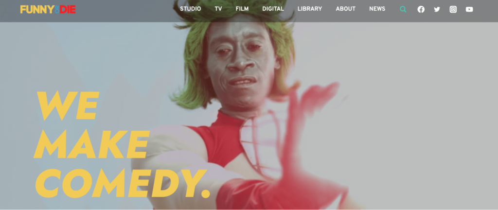A person in a colorful costume with green hair and a red top stands against a light background. Yellow text reads, We make comedy. The top menu includes links like Studio, TV, Film, and more.